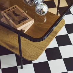 Mesa de centro vintage de metal negro con tapa de cristal y decoración de madera
