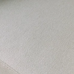Sillón de tela con respaldo curvo y patas de metal