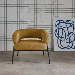 Sillón de tela con respaldo curvo y patas de metal