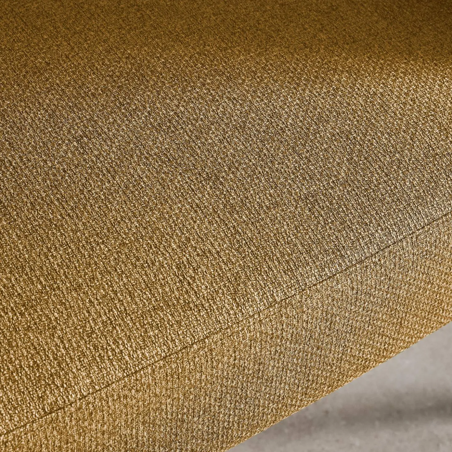 Sillón de tela con respaldo curvo y patas de metal