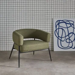 Sillón de tela con respaldo curvo y patas de metal