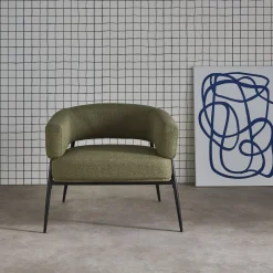 Sillón de tela con respaldo curvo y patas de metal