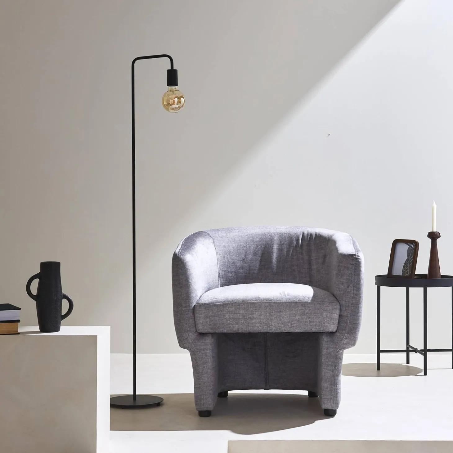 Sillón de tela con respaldo y base redondeada